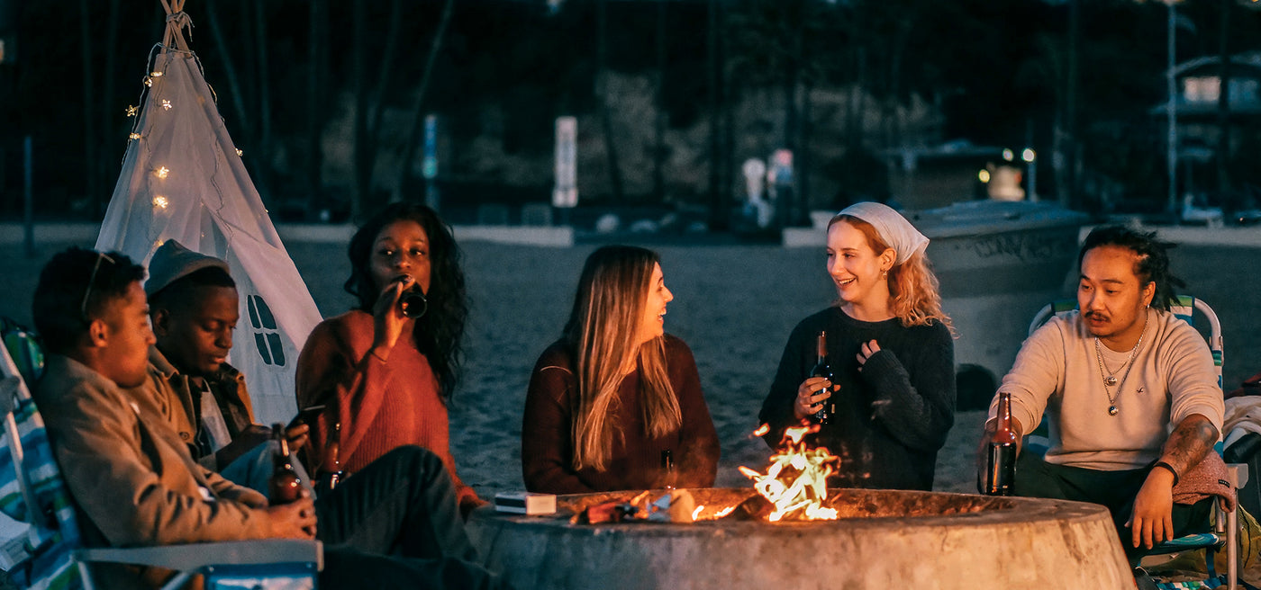 The brand story image of Yaber. A crowd surrounded by bonfire, drinking beer. They all looks happy.